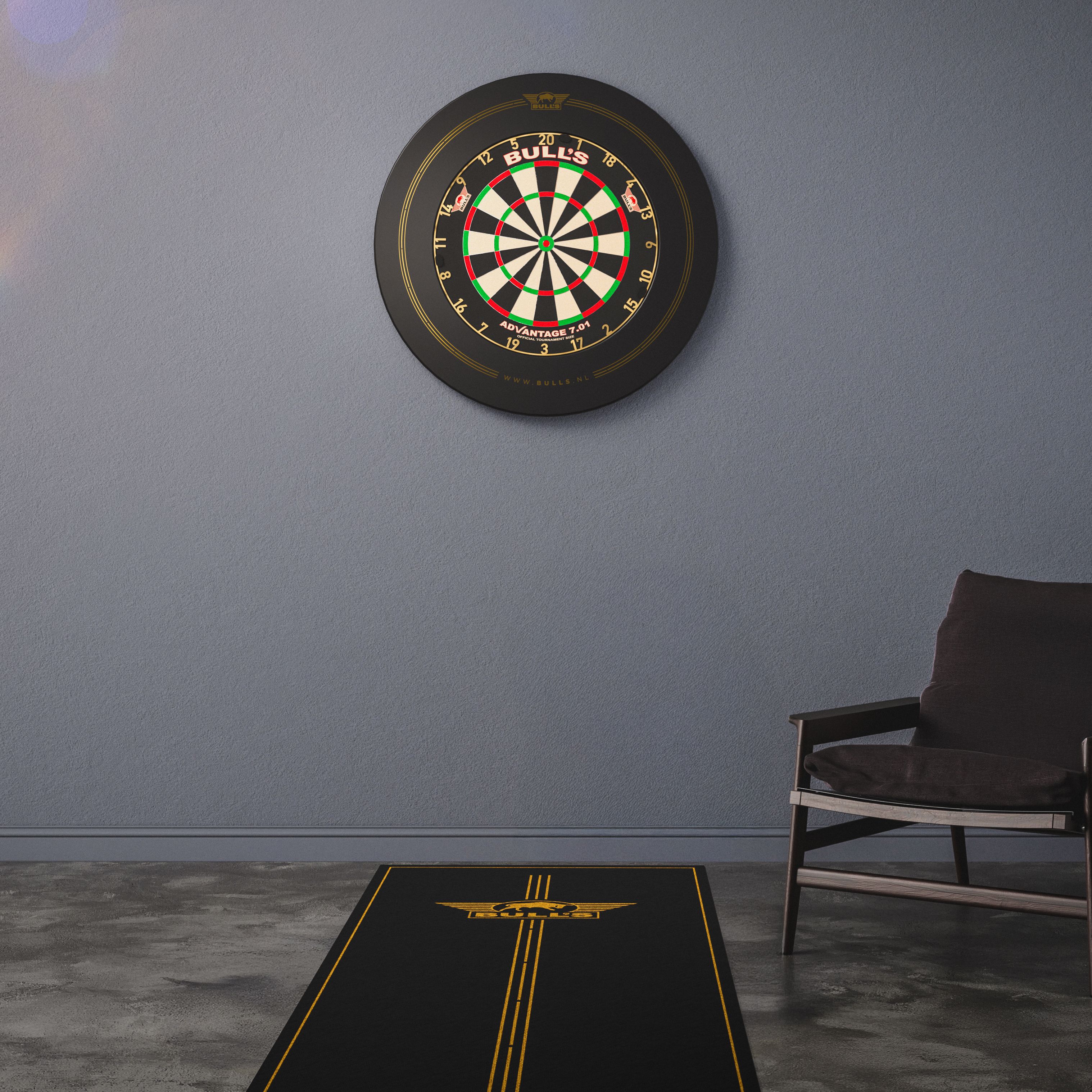Bulls NL Advantage Dartteppich Das Bild zeigt ein Bulls NL Advantage Dartteppich vor einer Dartscheibe an der Wand. Daneben steht ein moderner Stuhl in einem schlicht eingerichteten Raum.