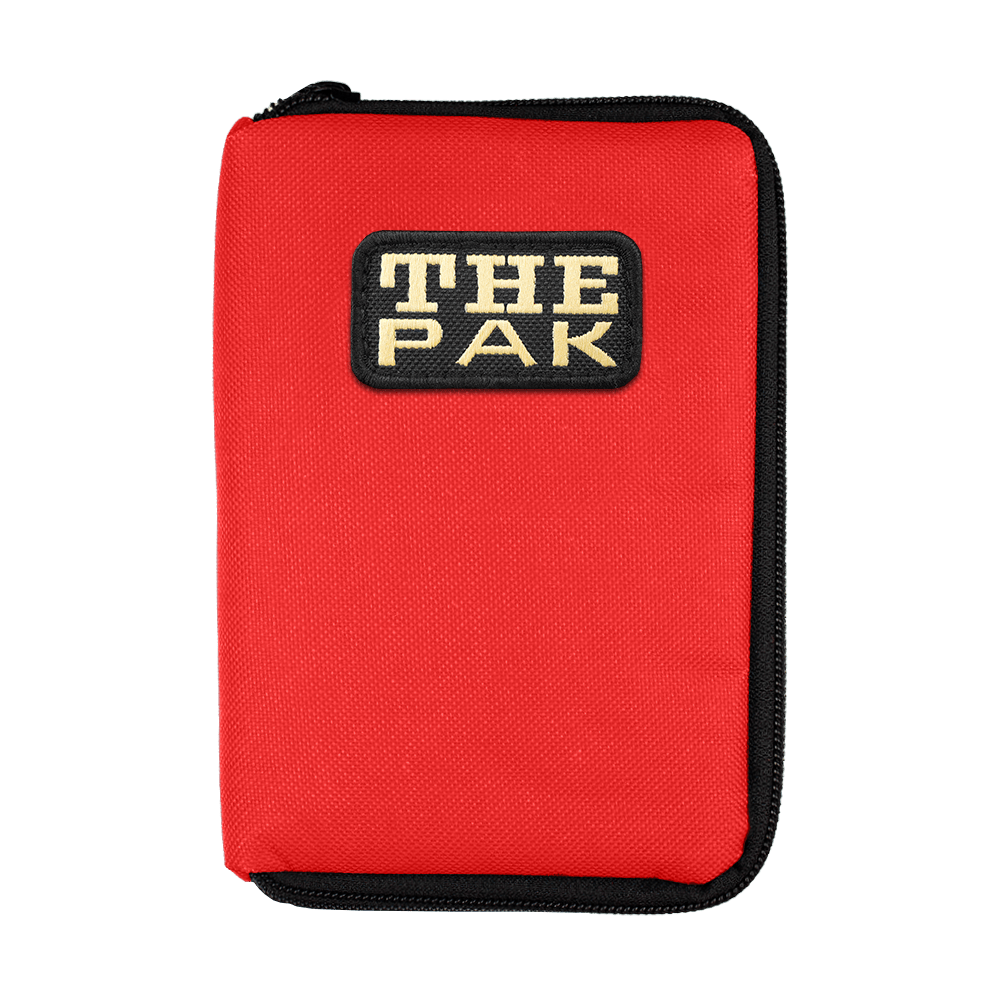 712TP_The_Pak_Dartcase_Rot_1 Das Bild zeigt ein rotes Etui mit schwarzem Reißverschluss. Auf der Vorderseite befindet sich ein Aufnäher mit der Aufschrift "THE PAK".