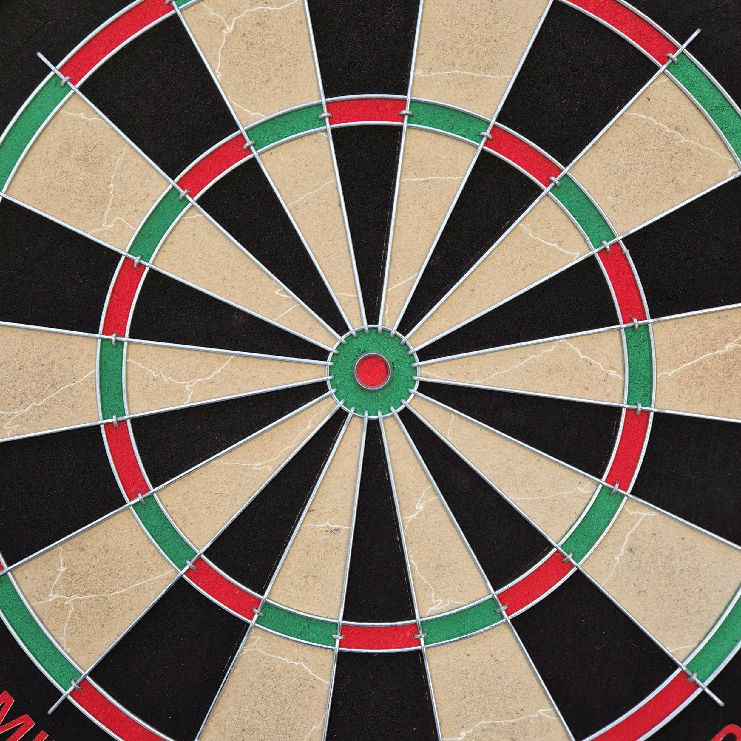 Target Dimitri Van Den Bergh stalen dartbordset Auf dem Bild ist eine Steeldartscheibe mit farbigen Segmenten in Rot, Grün, Schwarz und Beige zu sehen. Es handelt sich um das Produkt "Target Dimitri Van Den Bergh Steeldartboard Set".