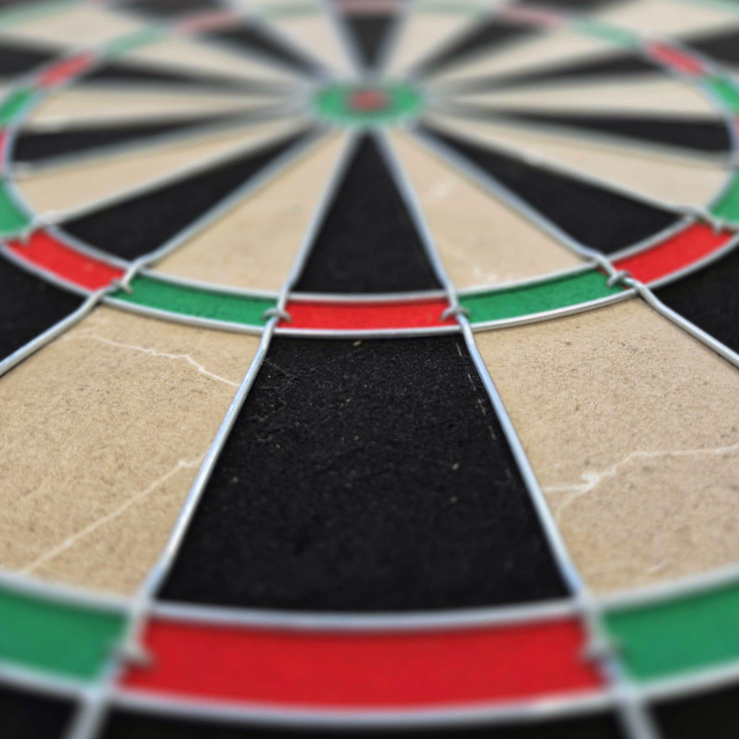 Target Gabriel Clemens stalen dartbordset Das Bild zeigt ein Steeldartboard mit farbigen Segmenten in Rot, Grün, Schwarz und Beige. Es handelt sich um das Produkt "Target Gabriel Clemens Steeldartboard Set".