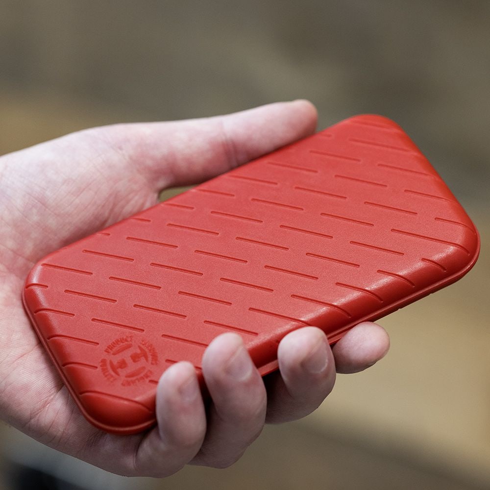 Harrows Slimcase Dart Case Eine Person hält eine rote, strukturierte Darttasche in der Hand. Die Darttasche hat eine schlanke und kompakte Form.