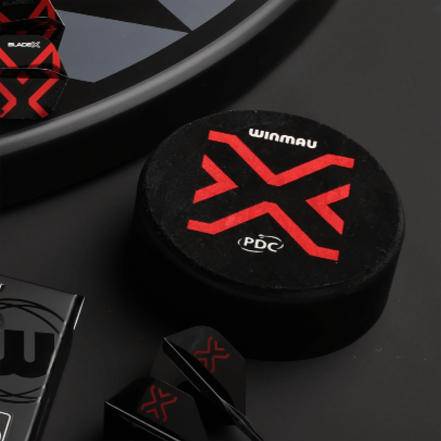 Der Winmau Dart Dock Blade X Dartständer ist auf dem Bild zu sehen. Es handelt sich um einen modernen Dartständer für Dartspieler.