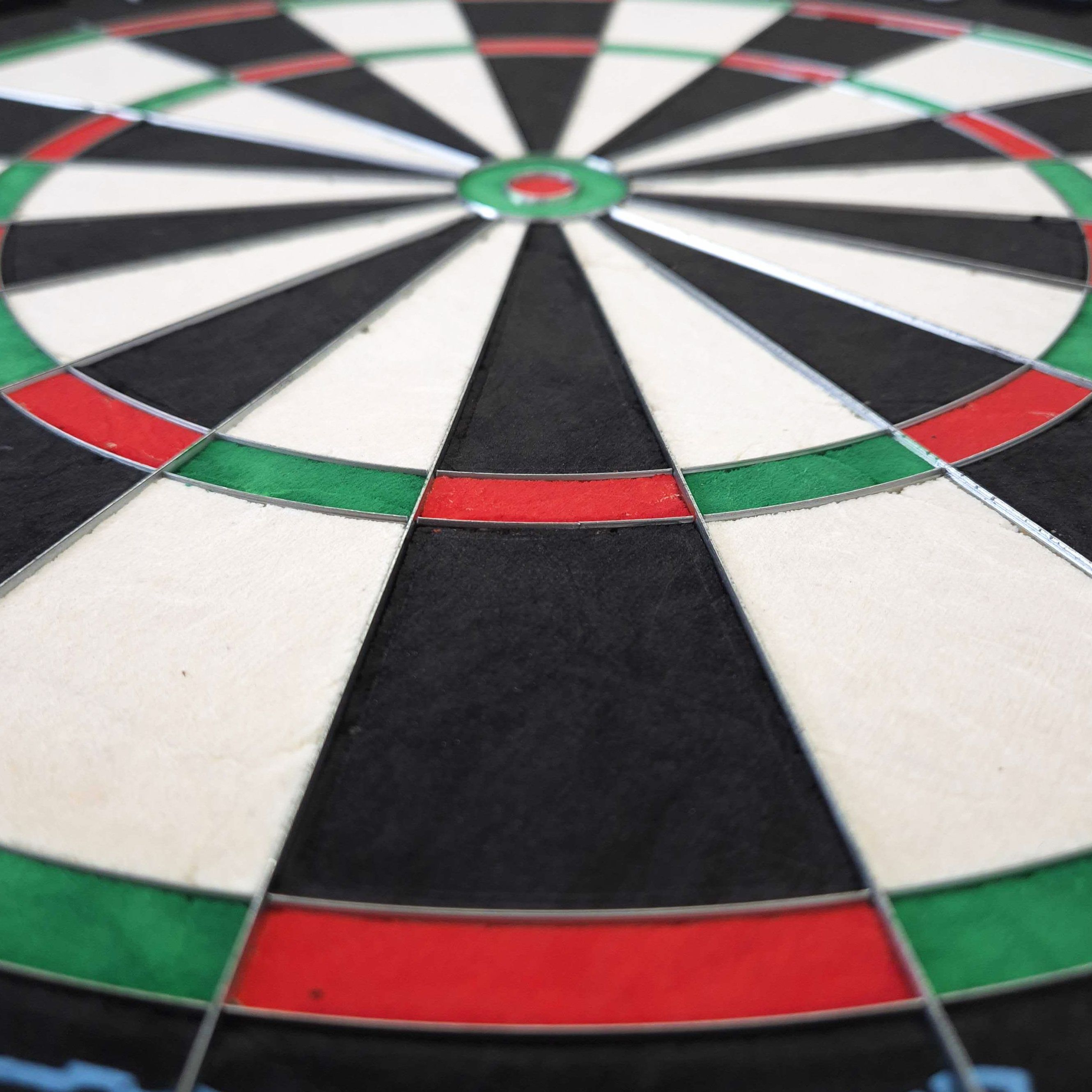 Mission Samurai Infinity stalen dartbord Das Bild zeigt eine Nahaufnahme eines Steeldartboards mit klar erkennbaren Farbfeldern in Rot, Grün, Schwarz und Weiß. Es handelt sich um das Produkt "Mission Samurai Infinity Steeldartboard".