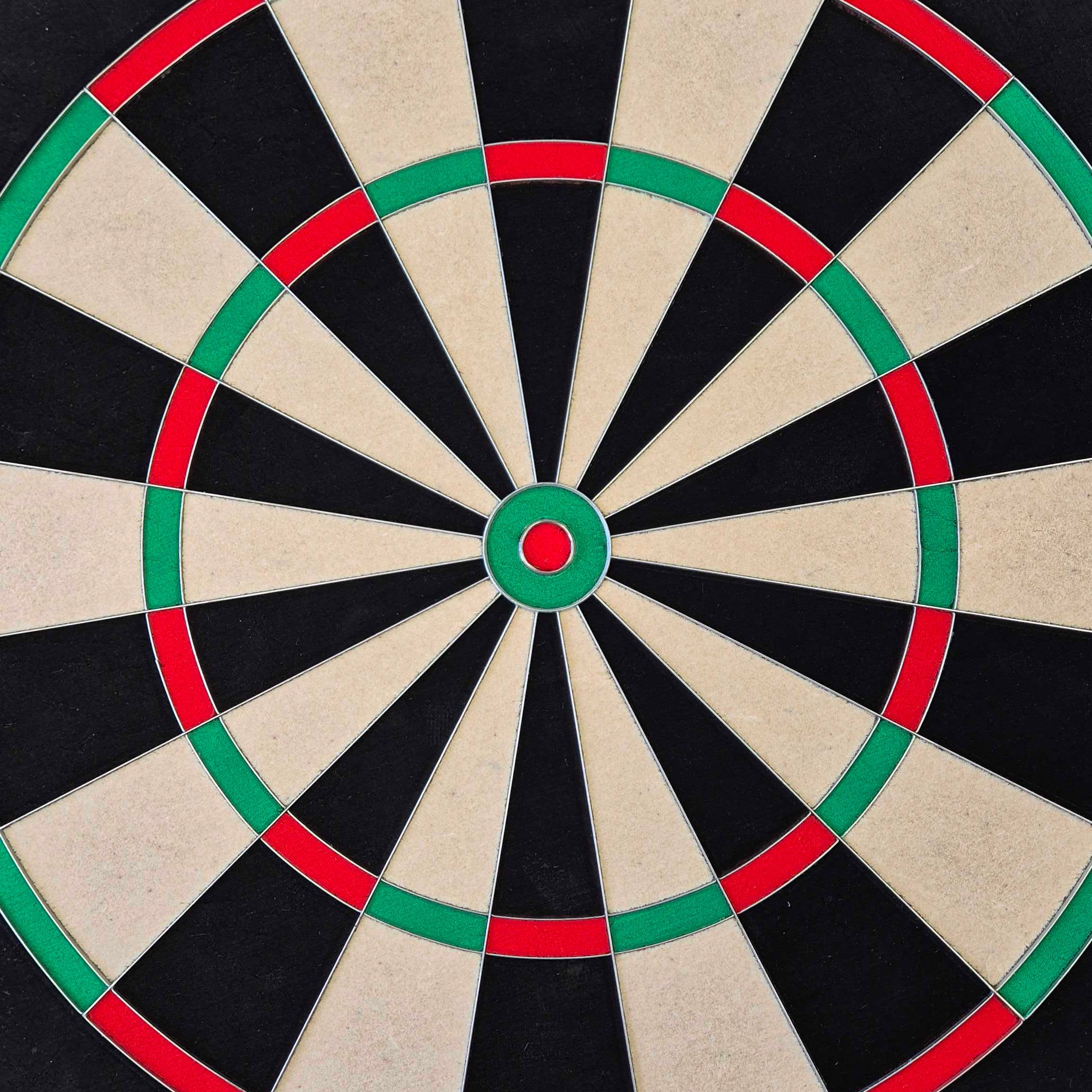 McDart Precision stalen dartbord Das Bild zeigt ein McDart Precision Steeldartboard. Die Dartscheibe ist in schwarze, beige, grüne und rote Segmente unterteilt.