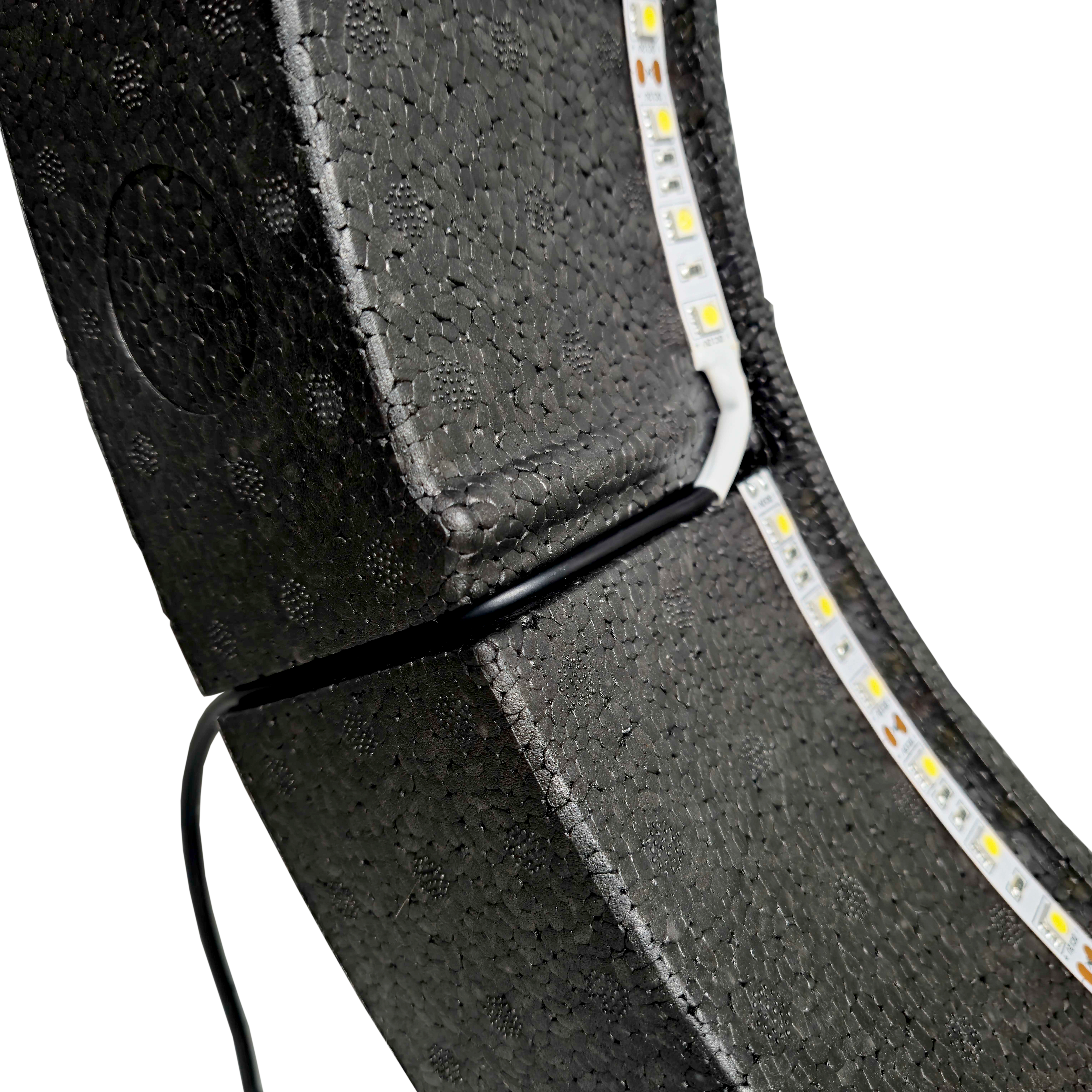 Bulls NL Lumo Light Surround verlichtingssysteem Das Bild zeigt das „Bulls NL Lumo Light Surround Beleuchtungssystem“ mit LED-Leuchtstreifen auf einer schwarzen, strukturierten Oberfläche. Ein Kabel ist ebenfalls an das Beleuchtungssystem angeschlossen.
