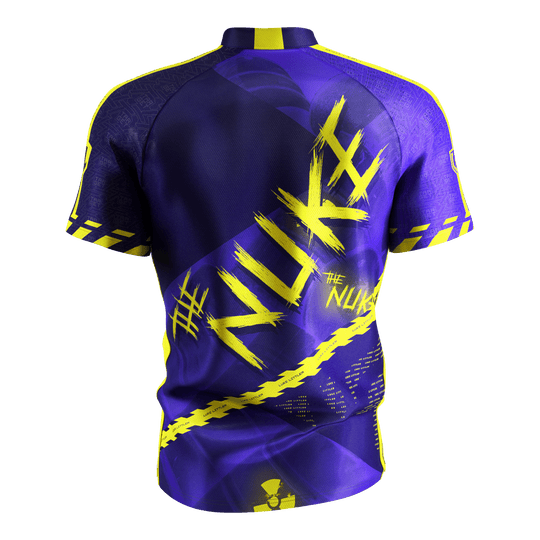 Target Coolplay Luke Littler 2025 dartshirt Das Bild zeigt das „Target Coolplay Luke Littler 2025 Dartshirt“ von hinten. Das Shirt ist überwiegend lila mit auffälligen gelben Designs und dem Schriftzug „NUKE“ auf dem Rücken.