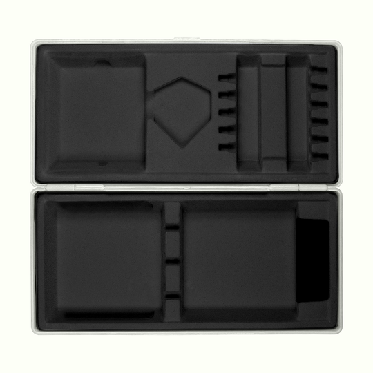 ABS-doos met eigen bedrukking Die Abbildung zeigt eine geöffnete graue Box mit passgenauen Fächern aus schwarzem Schaumstoff. Die Box liegt auf einem hellgelben Hintergrund.