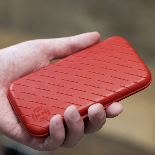 Harrows Slimcase Dart Case Eine Person hält eine rote, strukturierte Darttasche in der Hand. Die Darttasche hat eine schlanke und kompakte Form.