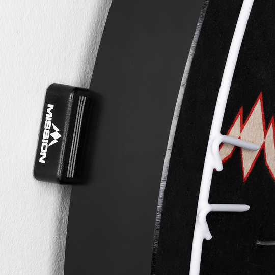 Mission Dartbord Wedges Spacers (Set van 8) Das Bild zeigt einen Abstandshalter der Marke Mission, der an einem Dartboard befestigt ist. Der Abstandshalter sorgt dafür, dass das Dartboard gleichmäßig von der Wand absteht.