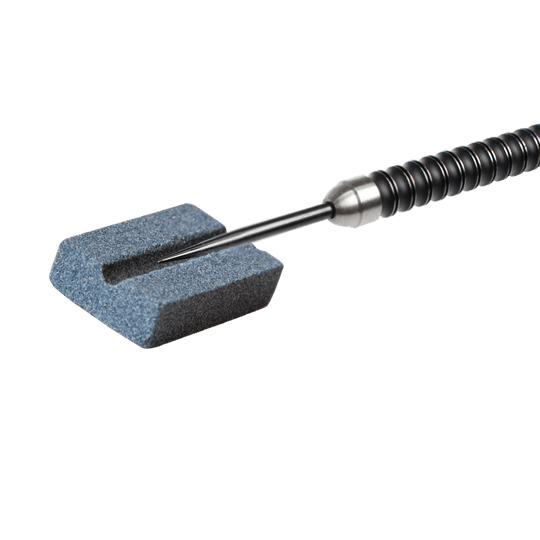 616_QD8200690_XQMax_Steeldart_Schleifstein_2 Das Bild zeigt einen XQMax Steeldart Schleifstein mit einem Dartpfeil darauf. Der Schleifstein wird verwendet, um die Spitze des Dartpfeils zu schärfen.