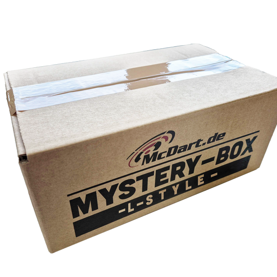 McDart Mystery Box - L-stijl Auf dem Bild ist ein brauner Karton mit der Aufschrift „McDart.de MYSTERY-BOX -L-STYLE-“ zu sehen. Die Box ist mit Klebeband verschlossen.