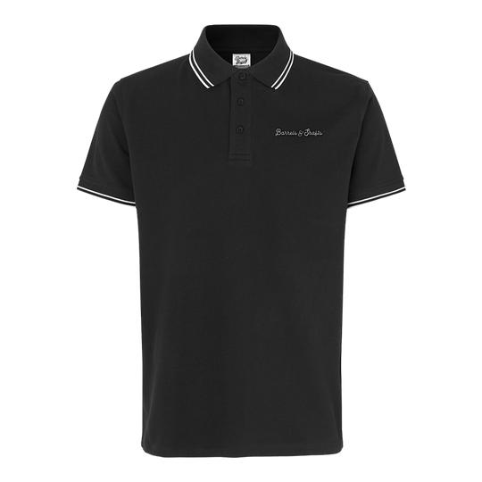Vaten en schachten poloshirt - zwart Das Bild zeigt ein schwarzes Poloshirt mit weißen Akzenten an Kragen und Ärmeln. Auf der Brust ist der Schriftzug "Barrels & Shafts" eingestickt.