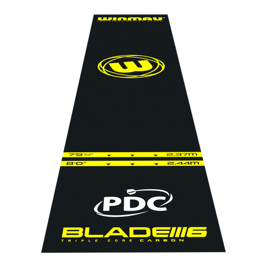 Winmau Pro-Zone Essential PVC dartmat Das Bild zeigt die Winmau Pro-Zone Essential PVC Dartmatte in schwarzer Farbe mit gelben Markierungen. Auf der Matte sind verschiedene Entfernungsmarkierungen, das Winmau-Logo sowie die Aufschrift "BLADE 6" und "PDC" zu sehen.